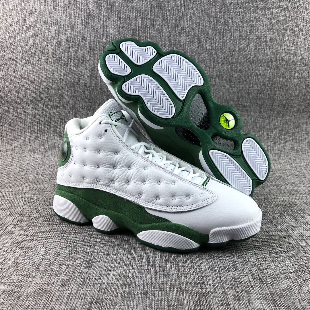 Three-quarter view of the sneakers with one shoe lifted to display the green-and-white outsole.