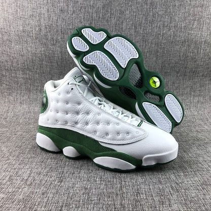 Three-quarter view of the sneakers with one shoe lifted to display the green-and-white outsole.