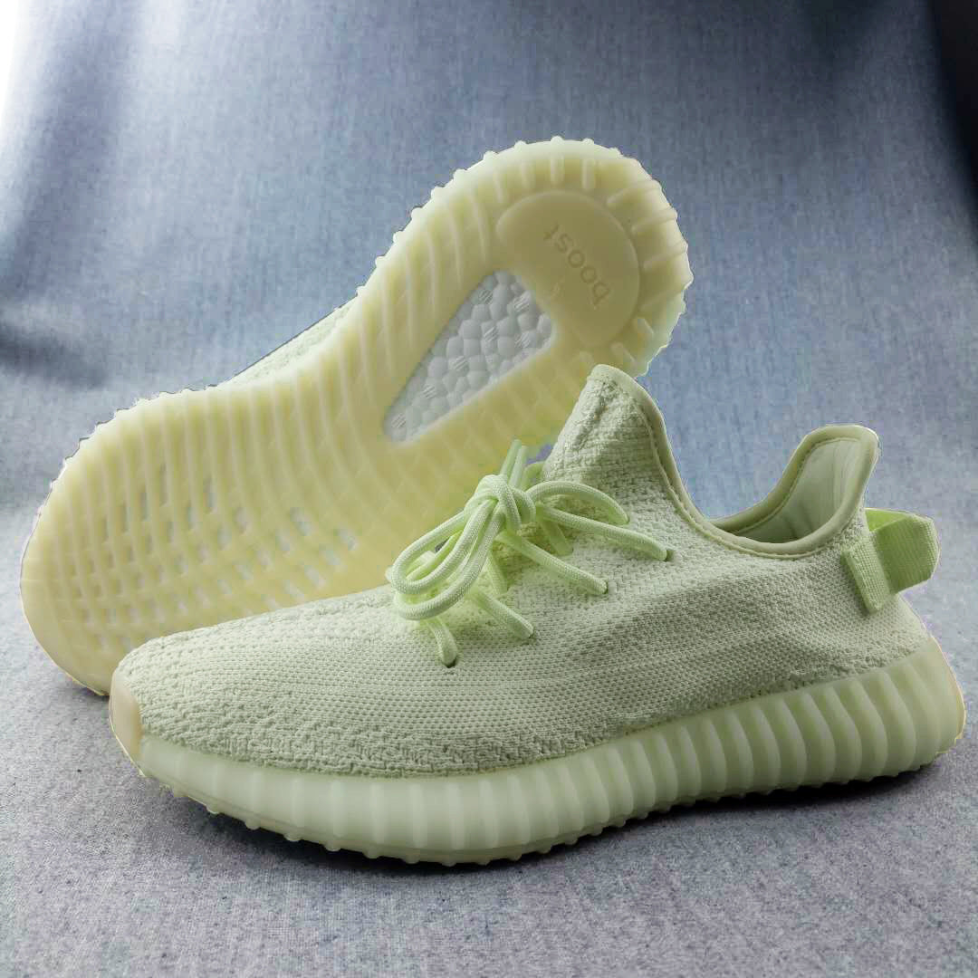 Three-quarter view of the pale butter-yellow sneakers, showing the textured upper, ribbed sole, and outsole detail.