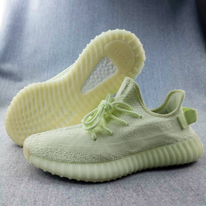 Three-quarter view of the pale butter-yellow sneakers, showing the textured upper, ribbed sole, and outsole detail.