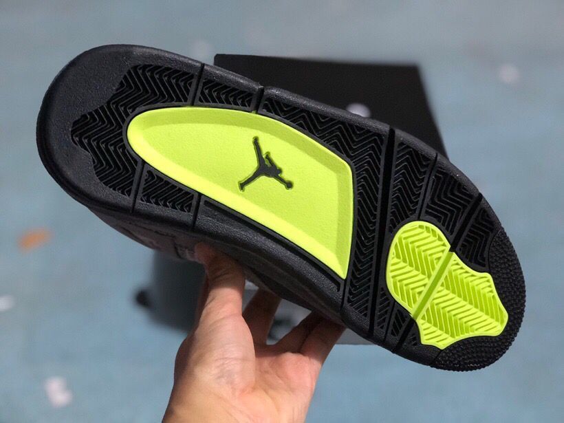 Underside view showing a black outsole with bright green traction sections and a Jordan logo.