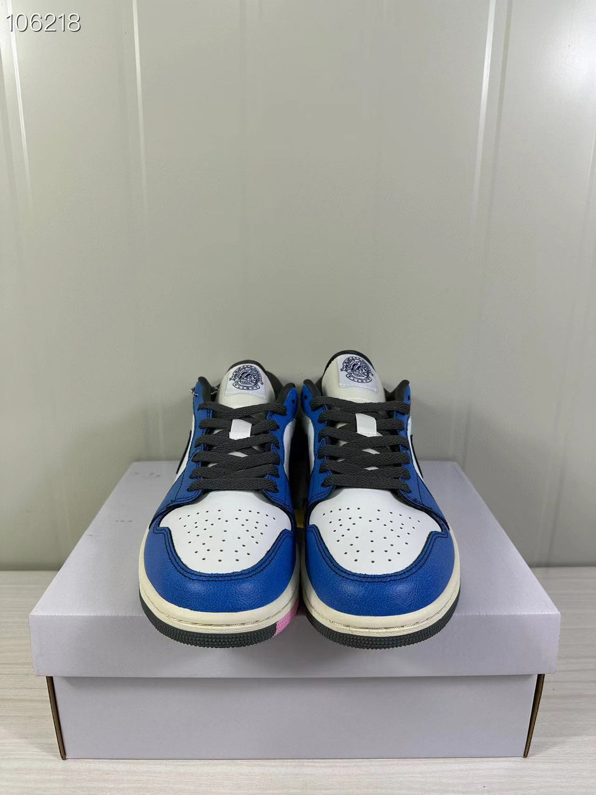 Front view of the pair showing black laces, blue overlays, and perforated white toe panels.
