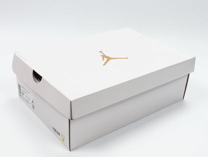 White Jordan shoe box with a gold Jumpman logo and a visible size label area.