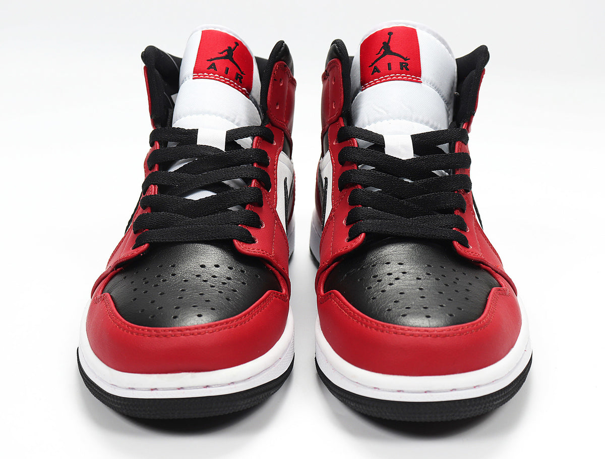 Front view of red, black, and white high-top sneakers with black laces and perforated toe boxes