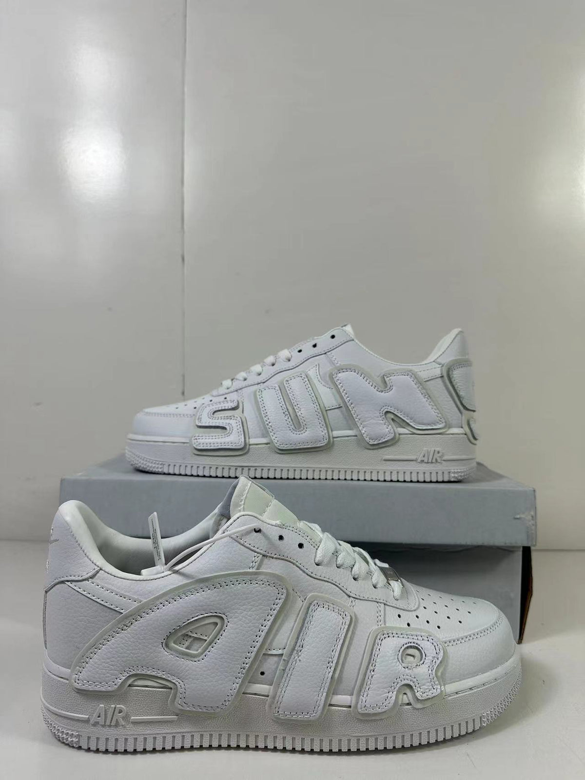 Angled product view showing the white upper, raised side lettering, and low-profile shape.