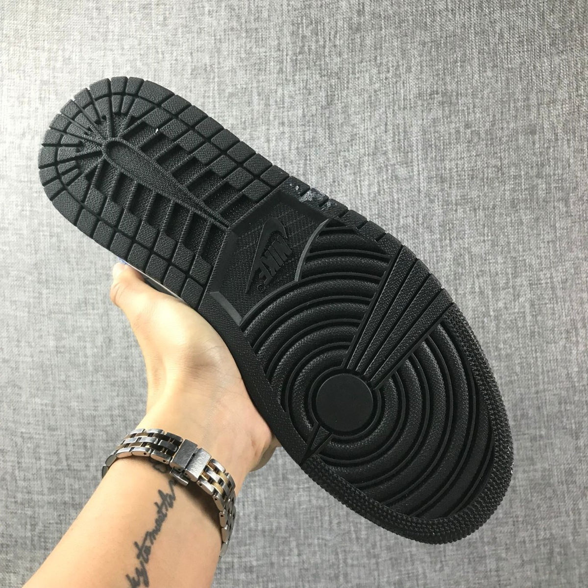 View of the black rubber outsole showing circular and segmented tread patterns.