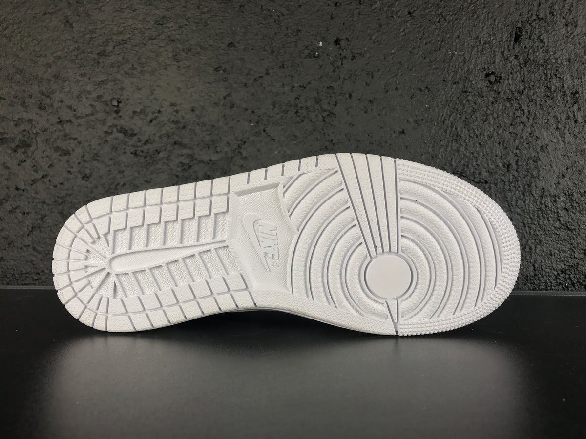 Close-up of the white rubber outsole showing circular forefoot traction and segmented tread blocks.