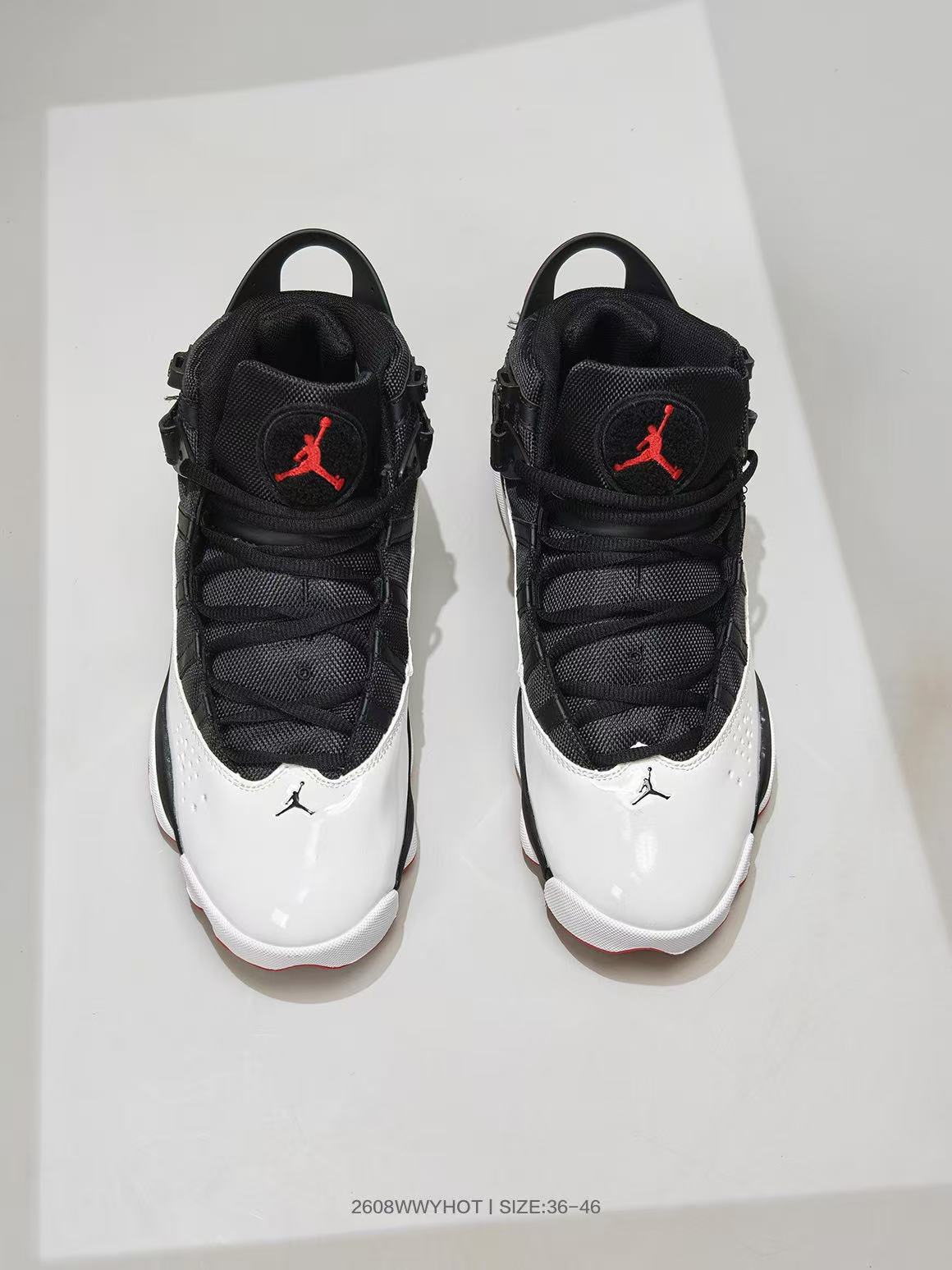 Top view of black, white, and red high-top sneakers with Jordan logos on the tongues.