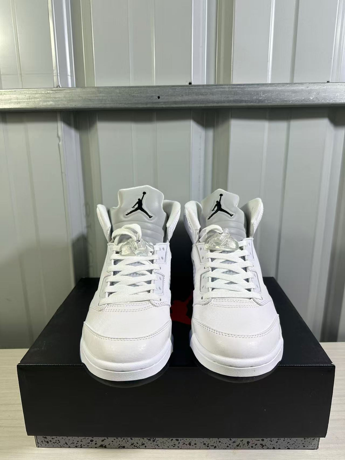 Front view of the pair showing white uppers, lace-up construction, and tongue branding.
