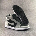 High-top sneaker displayed with one shoe lifted to reveal the black patterned outsole.