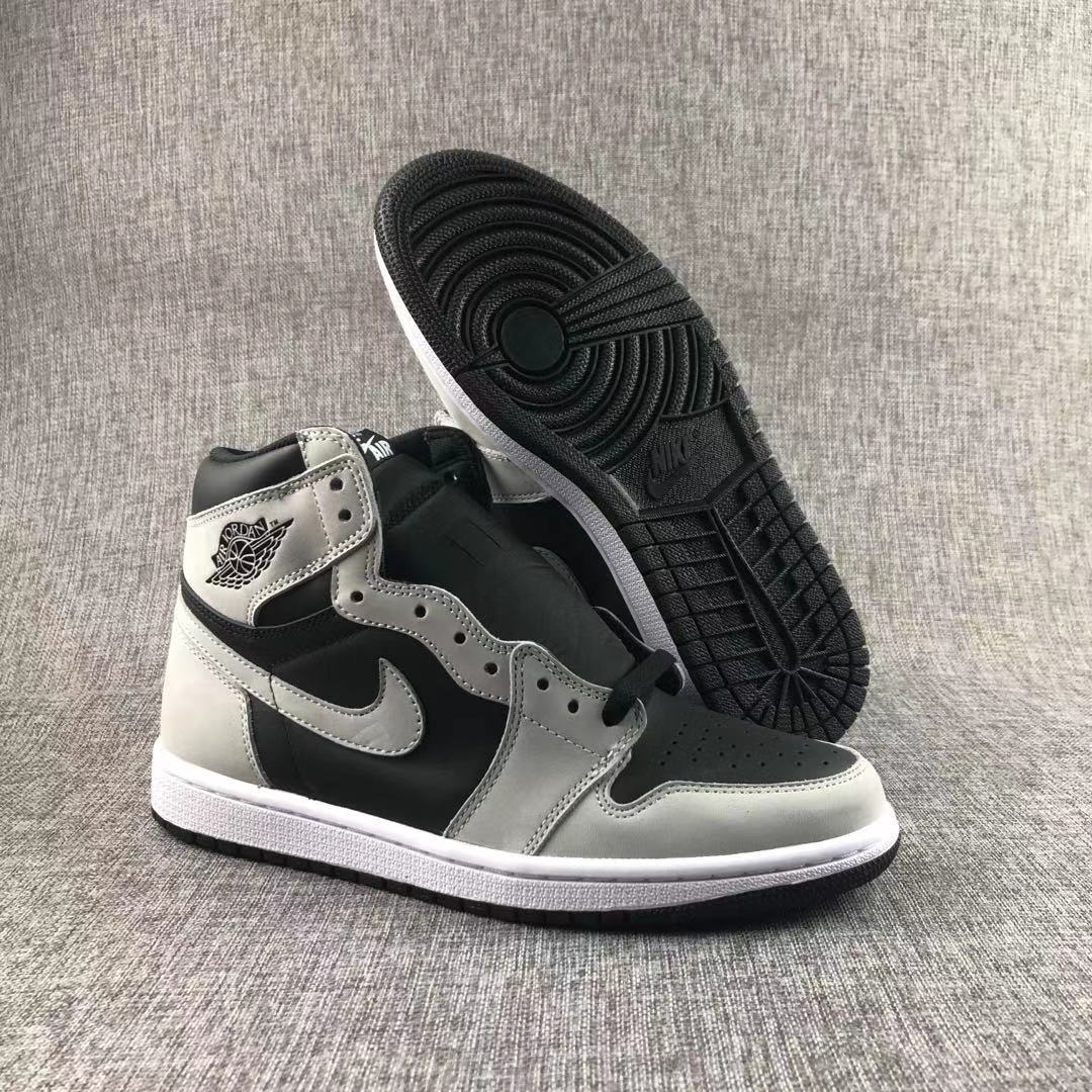 High-top sneaker displayed with one shoe lifted to reveal the black patterned outsole.