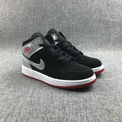 Three-quarter view of the black and silver sneaker pair with red outsole edges.
