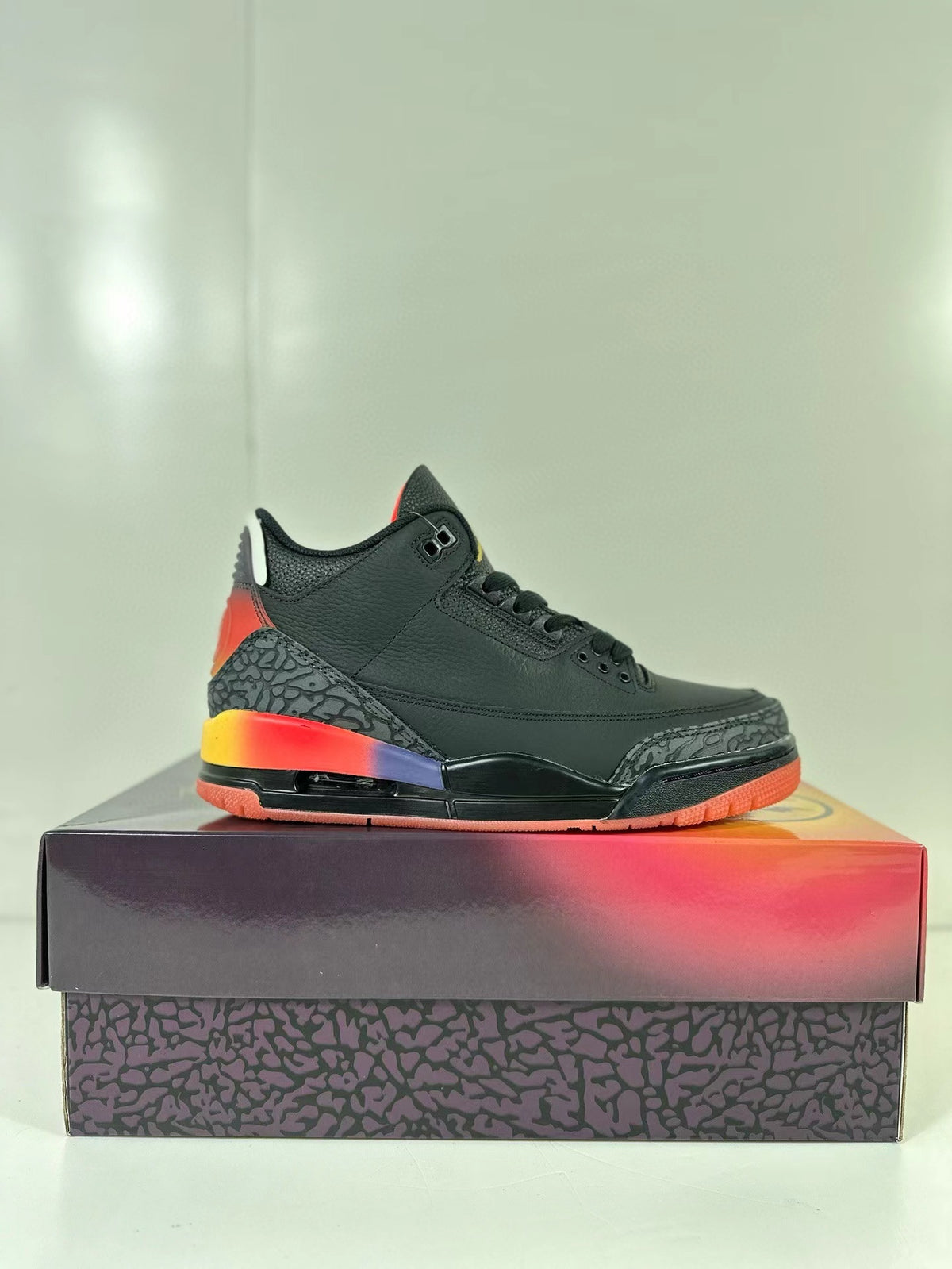 Single black Air Jordan 3 sneaker shown in side profile on the patterned shoebox.