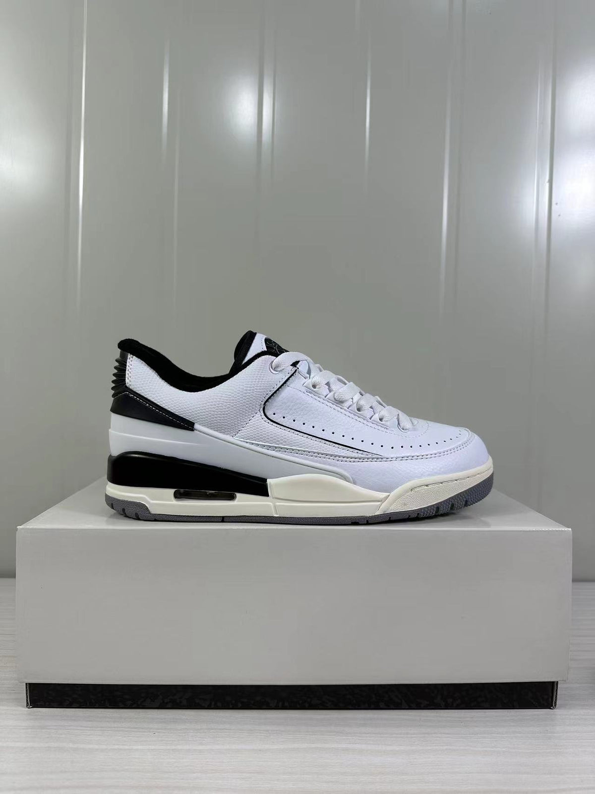 Single side profile of the white and black sneaker displayed on a product box.