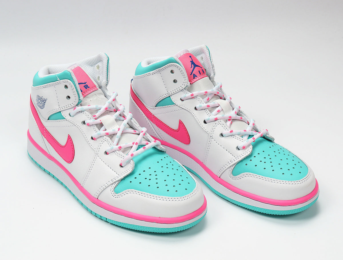 Angled front view of the high-top sneakers with pink Swoosh details and aqua toe panels.