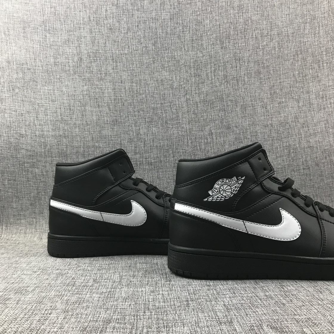 Pair of black and white mid-top sneakers displayed side by side.