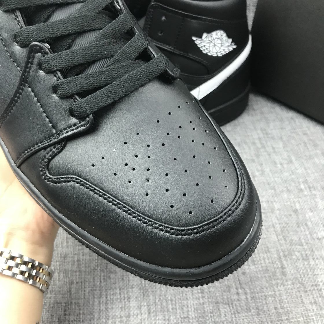 Close-up of the black perforated toe box, black laces and stitched panel construction.