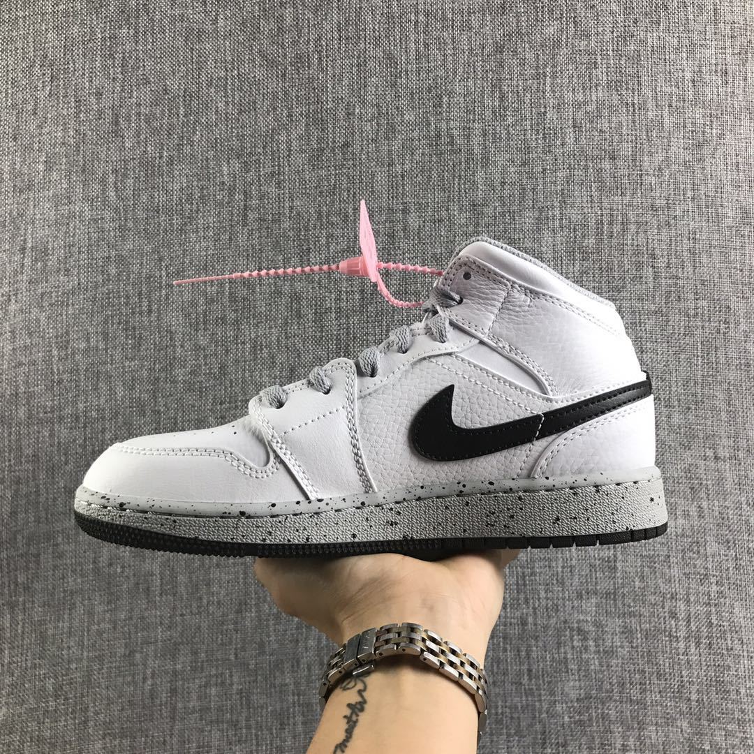 Side view of a white and black high-top Jordan sneaker with grey laces and a speckled grey midsole.