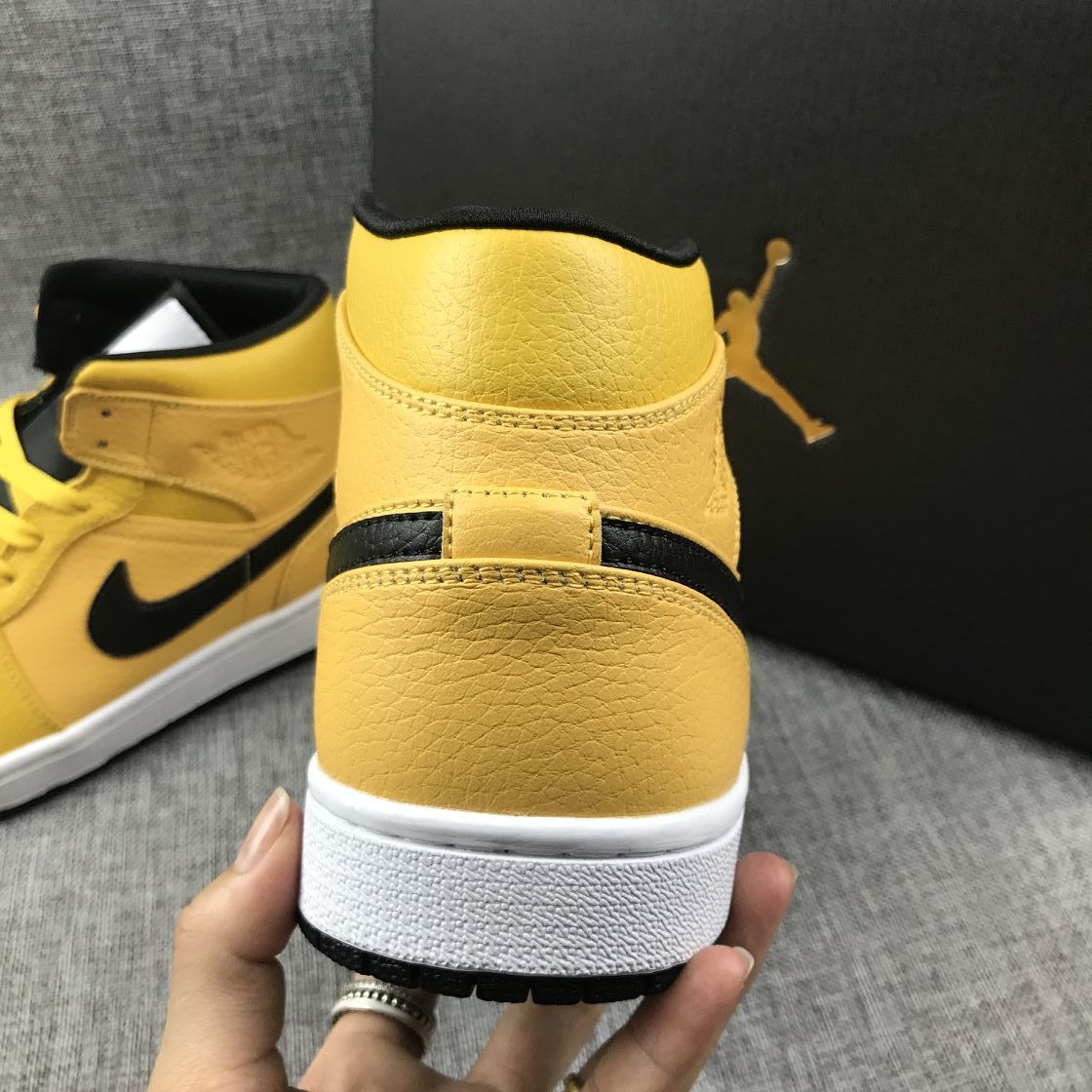Close rear view of the yellow high-top sneaker showing stitching, ankle padding, and the white midsole.
