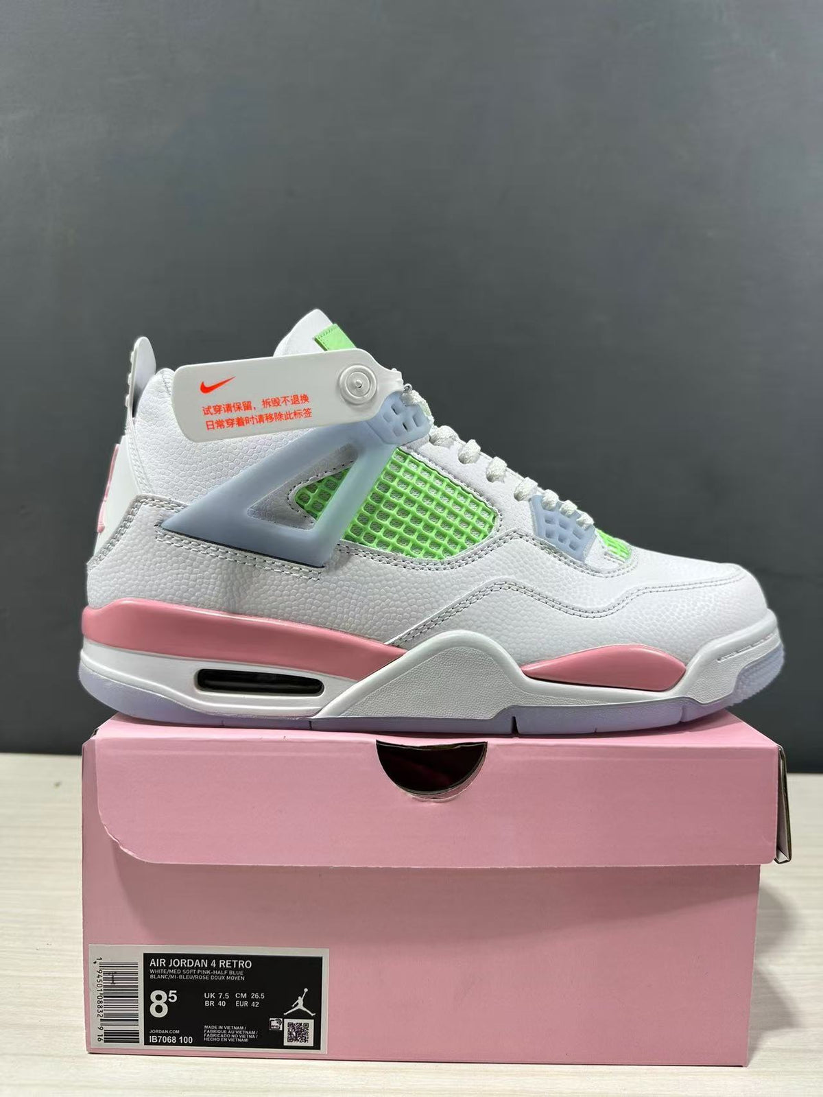 Single side view with the pink box label visibly identifying Air Jordan 4 Retro, style code IB7068 100, and EU 42 sample sizing.
