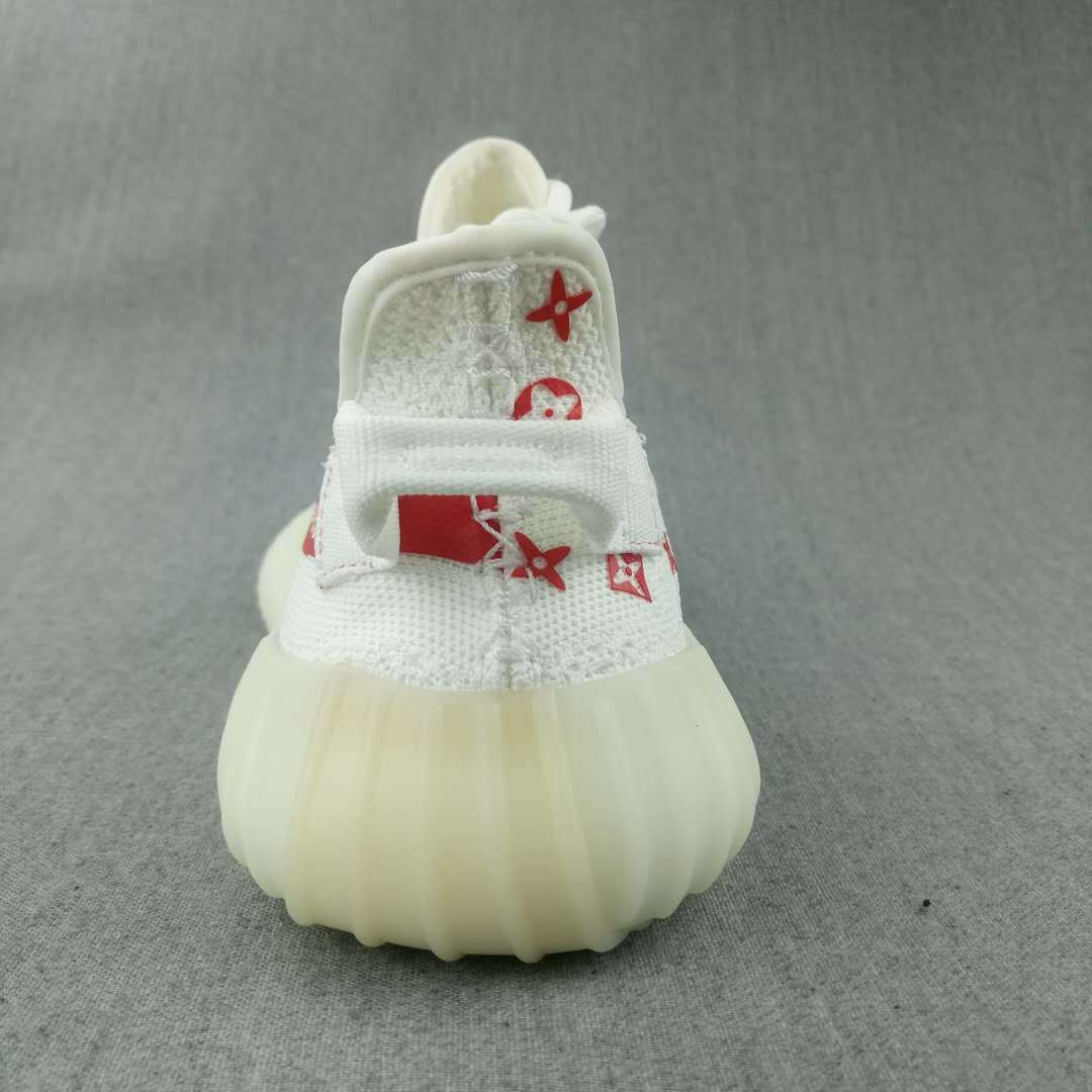 Front view of the white sneaker showing the rounded toe, red printed details, laces, and translucent sole.