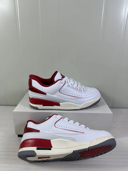 Side and angled view showing the white upper, red heel and midsole accents, and gray outsole.