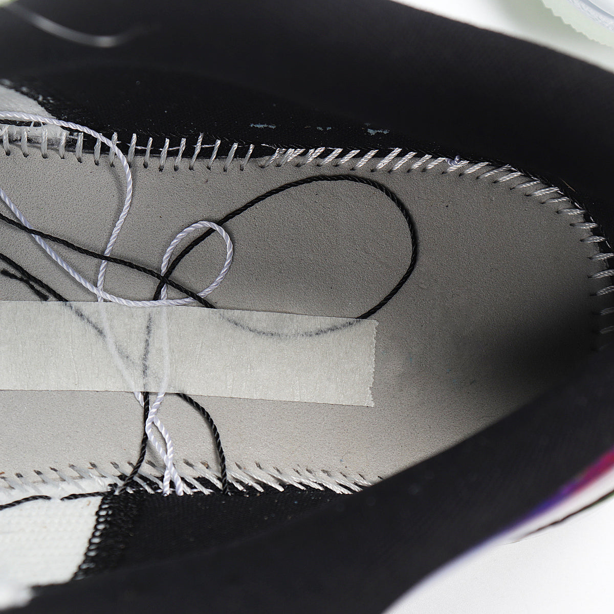 Close-up of the sneaker interior showing gray lining, black trim, and visible stitching.