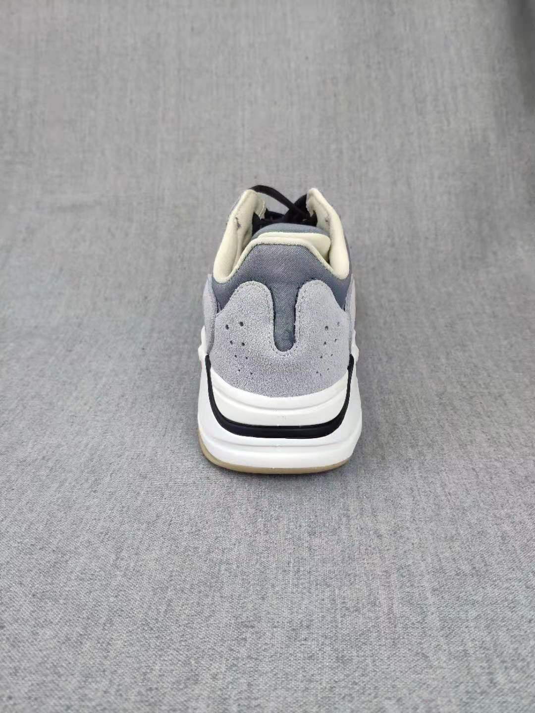 Rear view showing the layered grey heel panels, padded collars, white midsoles, and black heel detail.
