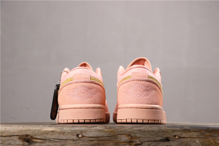 Rear view of the coral pink sneaker pair showing matching heel panels, stitched branding, and treaded rubber outsoles.