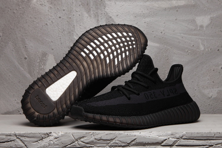 Black Yeezy 350 V2 sneakers shown from the side and sole, highlighting the ribbed outsole and tonal SPLY-350 stripe.
