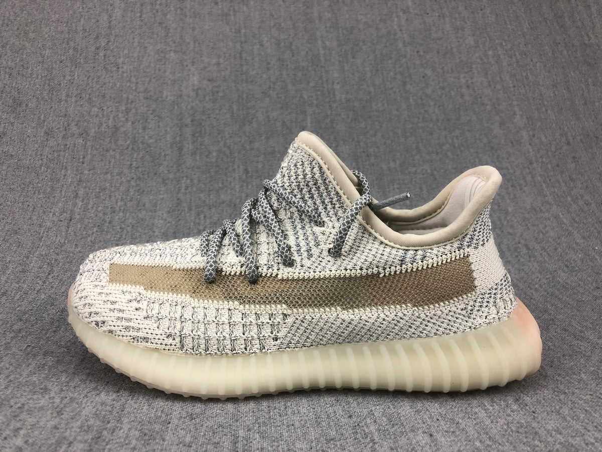 Side profile showing the cream-white knitted upper, contrasting stripe, and ribbed translucent sole.