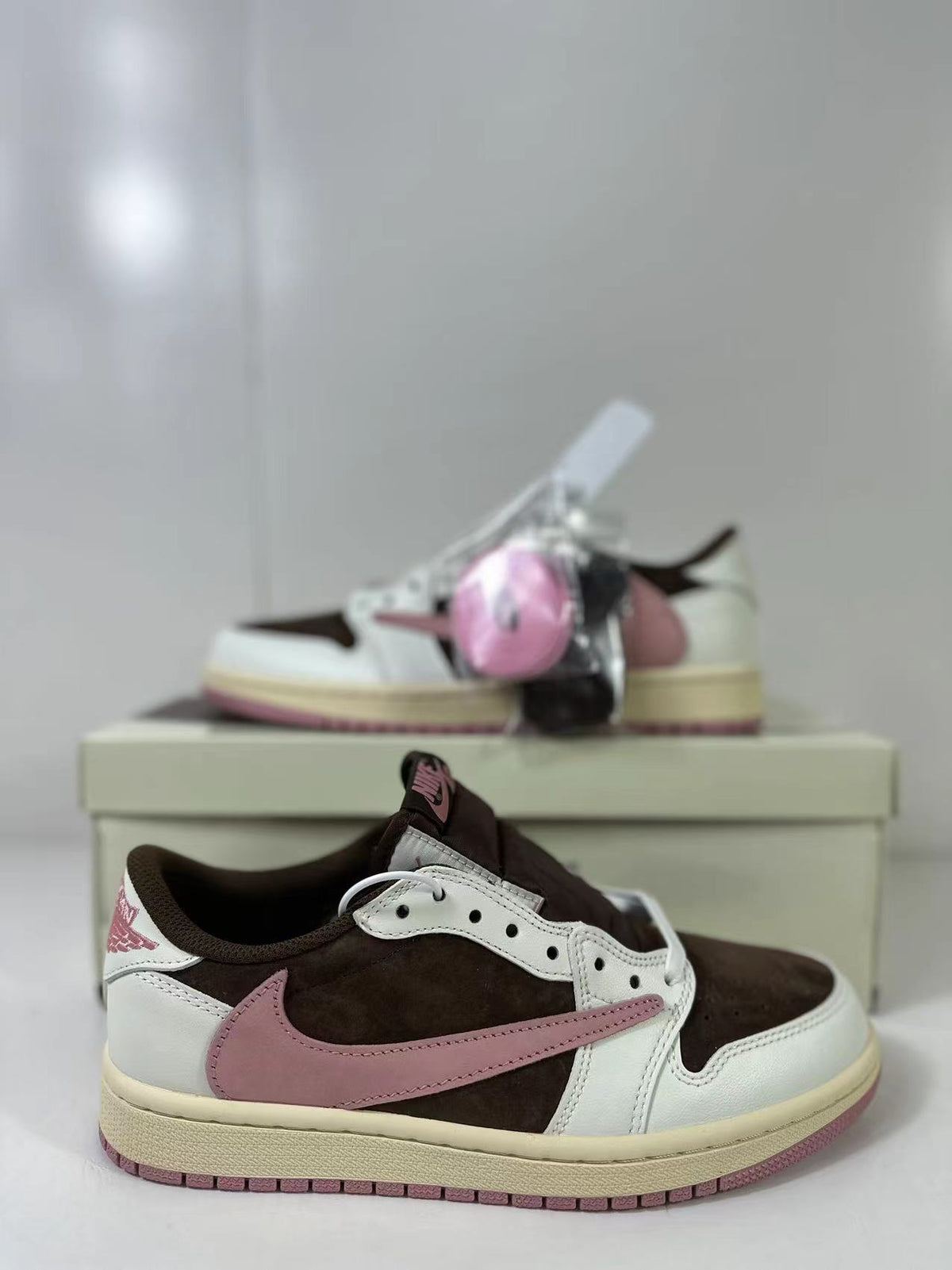 Close side view showing the reversed pink Swoosh, perforated eyestay, and brown collar.