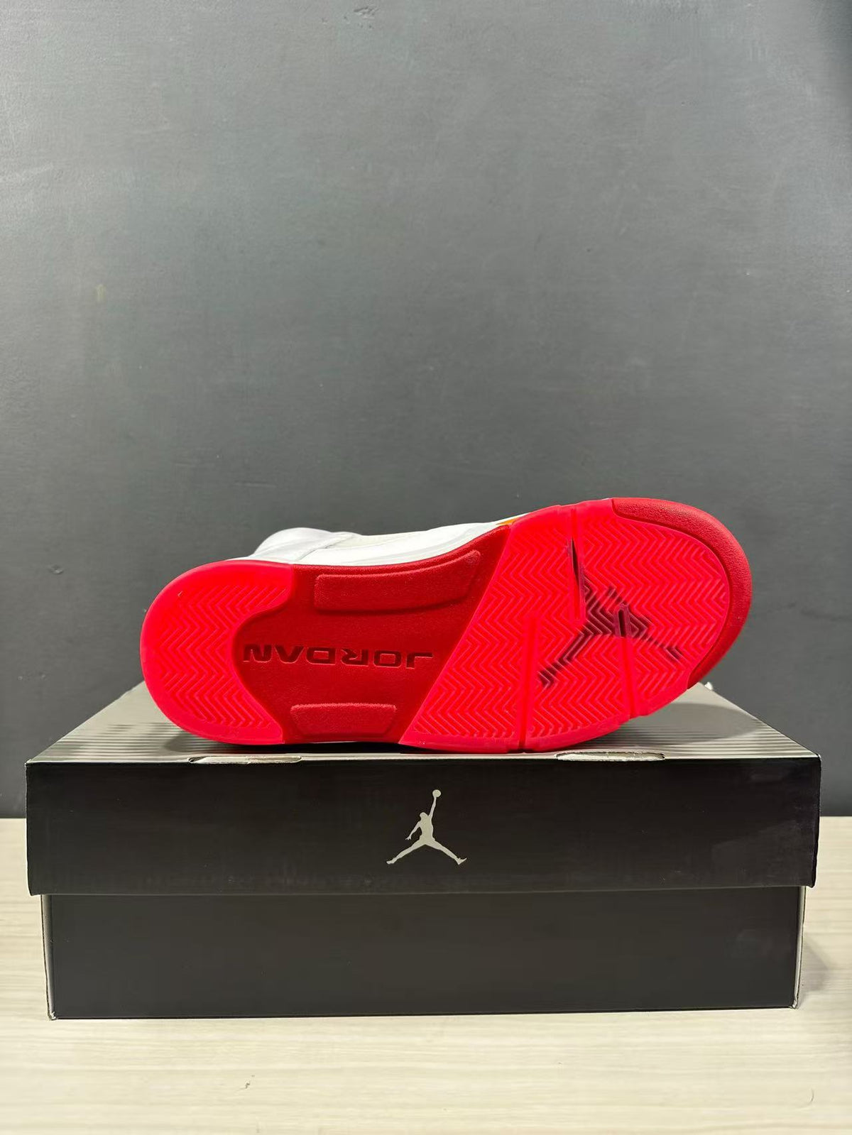 Bottom view of the sneaker showing a red textured rubber outsole with Jordan branding.