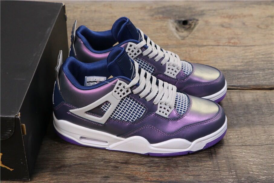 Side view of the pair beside the box, showing purple-blue uppers, white wing supports, mesh panels, and white midsoles.