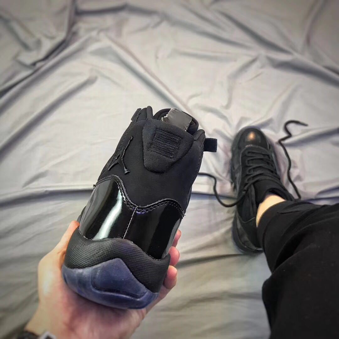 Rear view of a black high-top sneaker showing the padded collar and translucent heel outsole.