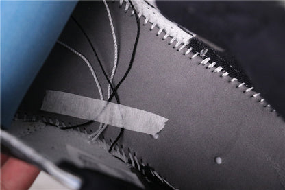 Close-up of the interior stitching and lace area of a black shoe.