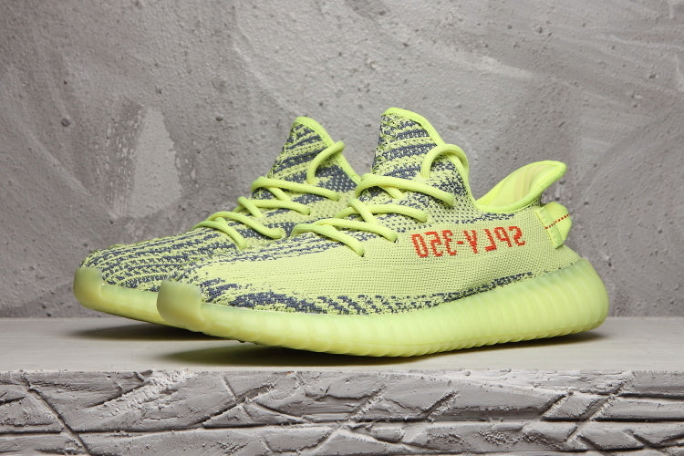 Pair of lime green knit sneakers shown in a three-quarter front view.