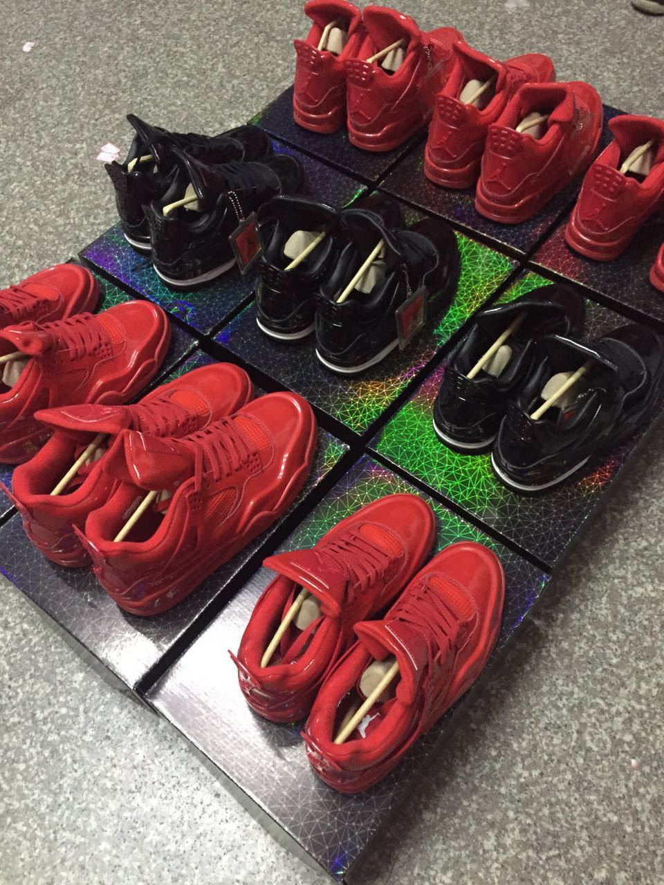 Rear and angled group view showing red and black high-top sneakers with heel tabs and patterned boxes.