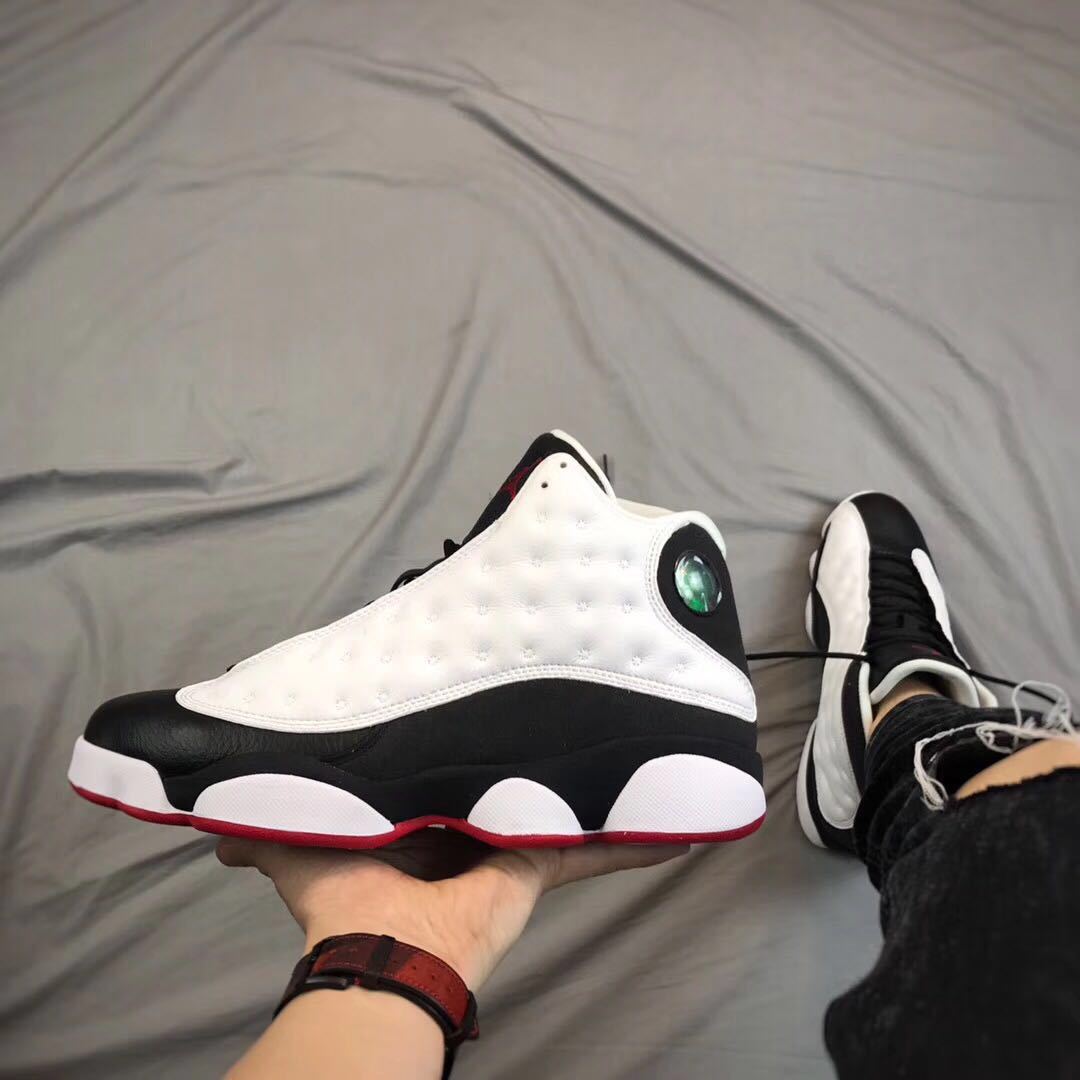 Side view of one sneaker held in hand with a second shoe in the background.