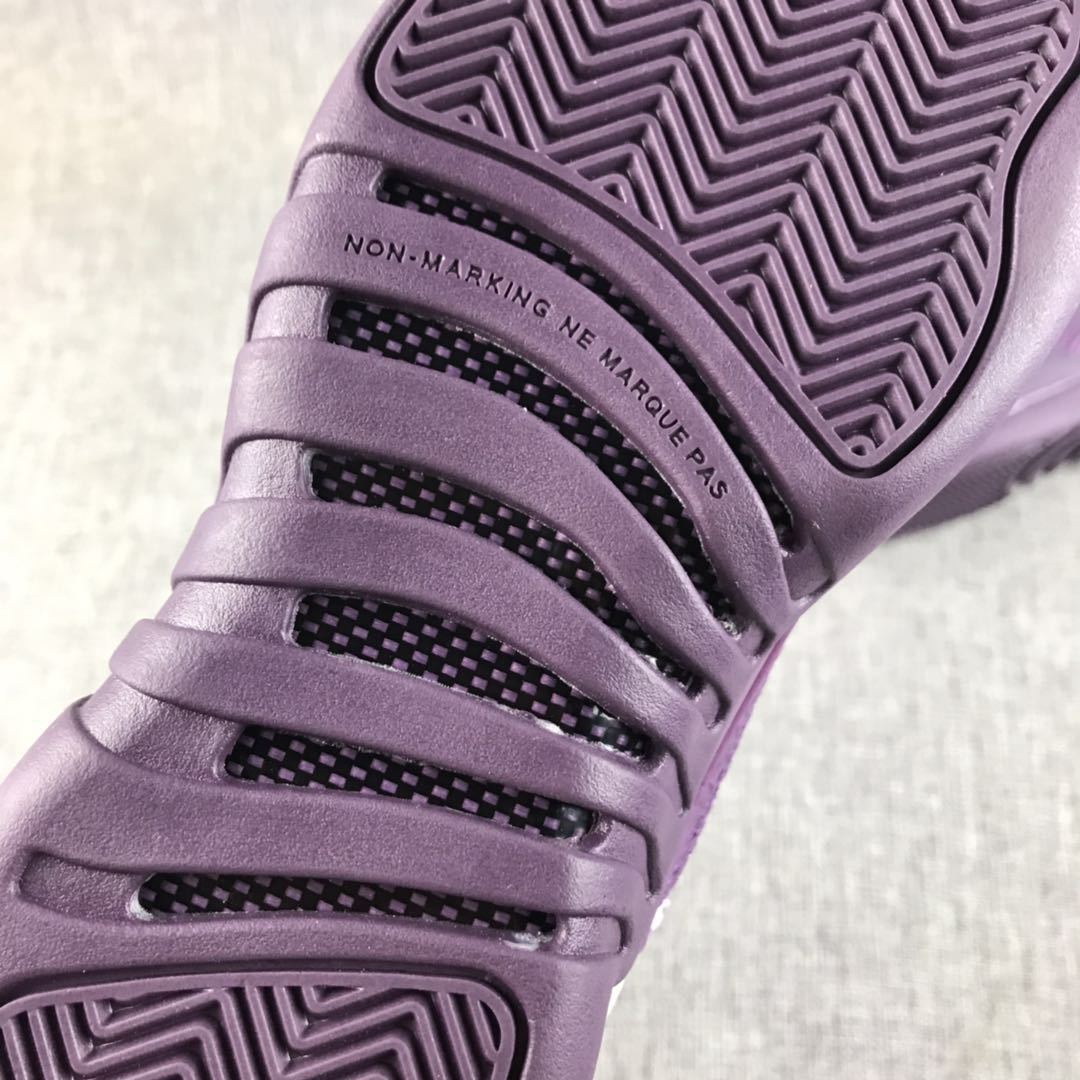 Close-up of the purple outsole with patterned tread and non-marking text