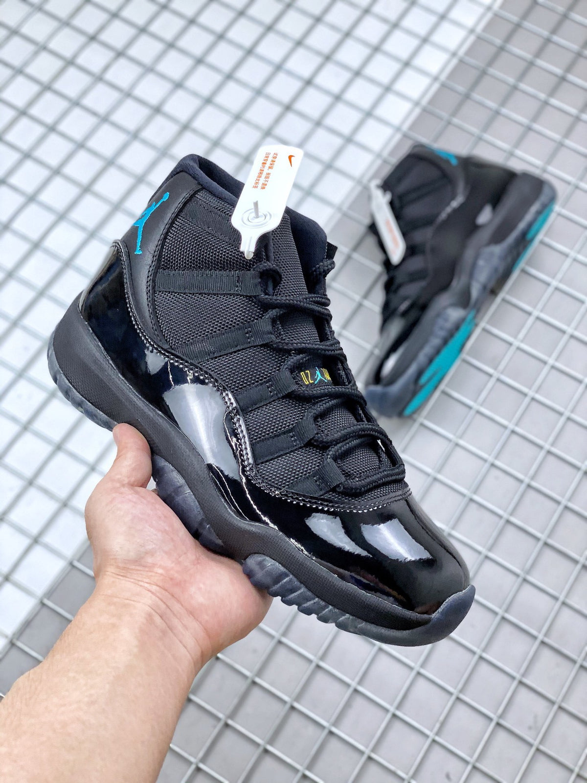 Three-quarter view of the black sneaker showing glossy toe and side panels with blue ankle branding.