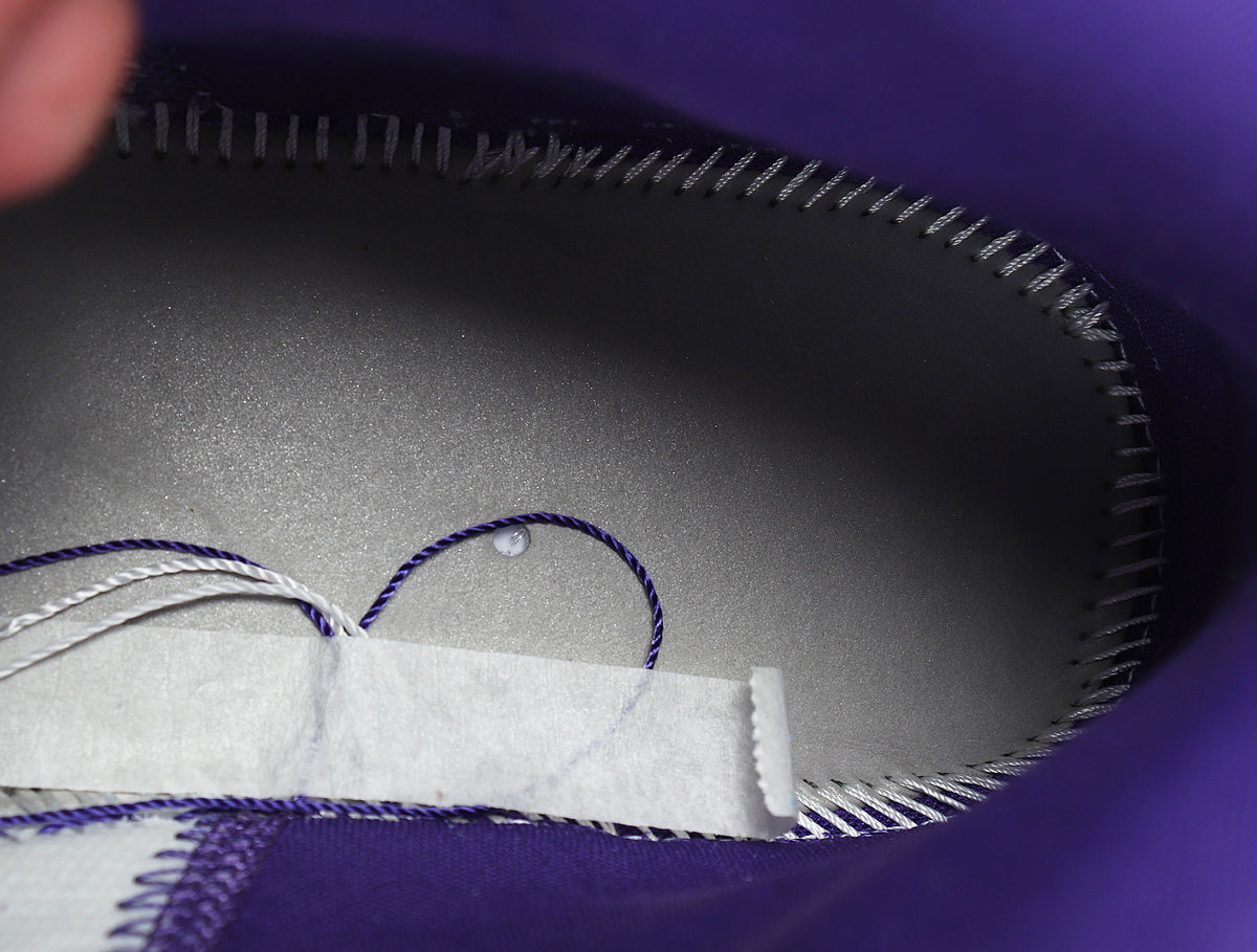 Close-up of the purple shoe interior, stitching and loose lace ends.