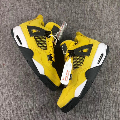Overhead product view showing the yellow and black pair with side mesh panels, attached tags, and extra laces.