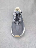 Top-down view showing the grey layered upper, black laces, tongue, and contrasting panels.