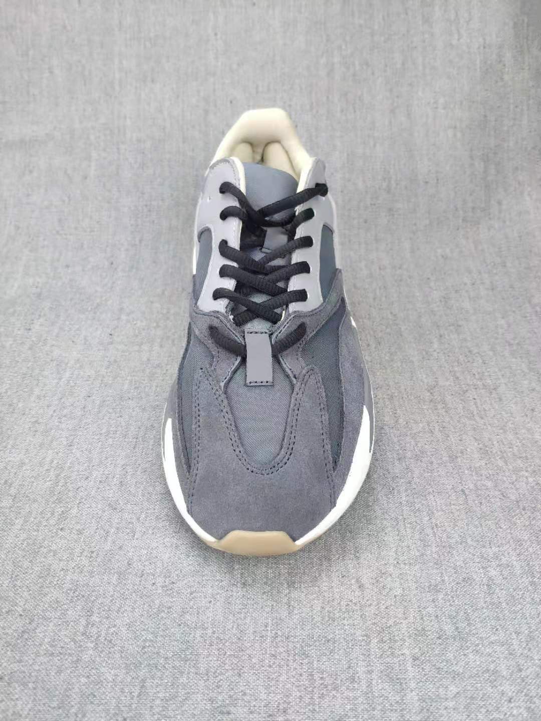 Top-down view showing the grey layered upper, black laces, tongue, and contrasting panels.