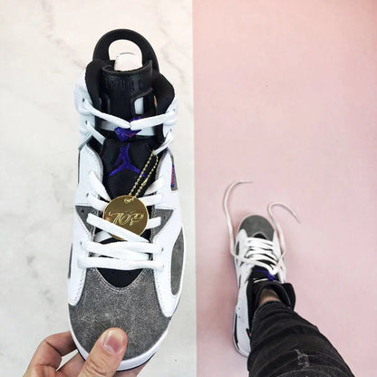 Top view of the sneaker showing the grey toe area, white laces, black tongue, and purple branding.