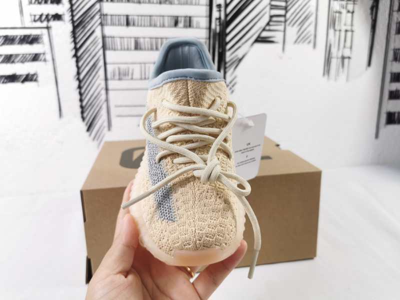 Front view of the lace-up sneaker showing the textured upper, gray stripe, and blue-gray lining.