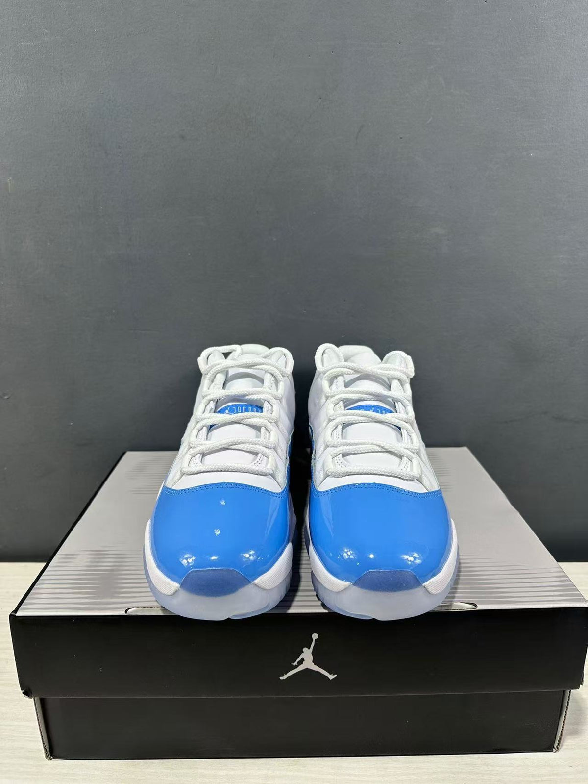 Front view of the pair showing white laces, blue toe panels, and low-top collars.