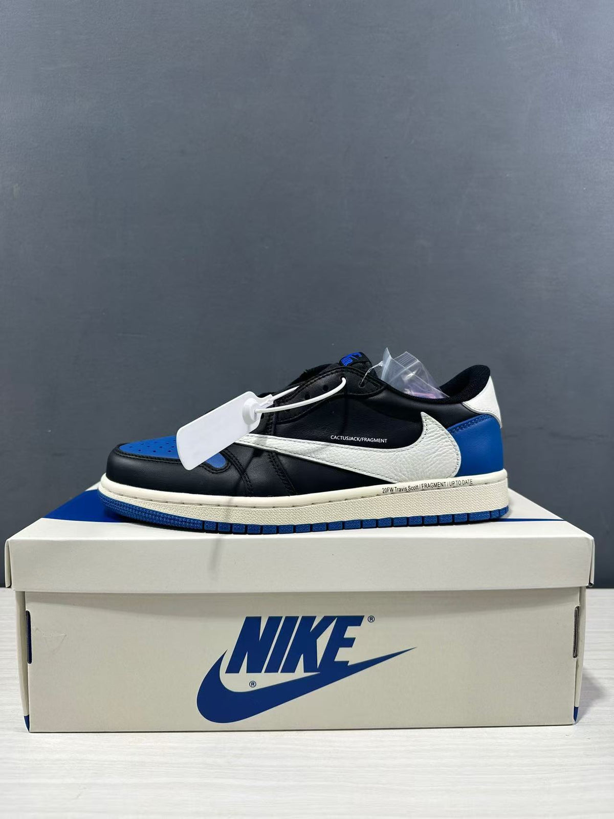 Side profile of the sneaker with black panels, white Swoosh, blue heel, and blue outsole.