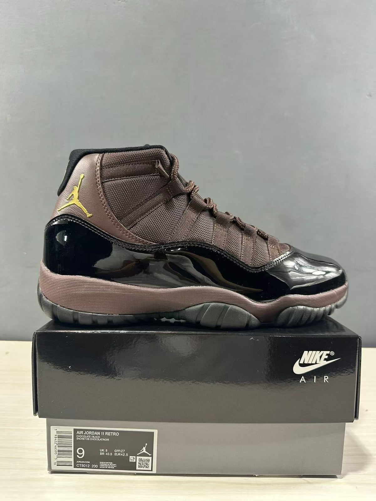 Side view of the sneaker with a shoebox label showing Air Jordan 11 Retro, size 9, UK 8, CM 27, EU 42.5, and style code CT8012 200.
